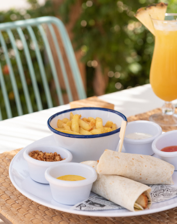 Burritos with chips accompanied by different types of sauces