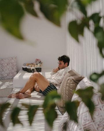 Guests of Eques Petit Resort reading in one of the outdoor chill out areas with cushions.