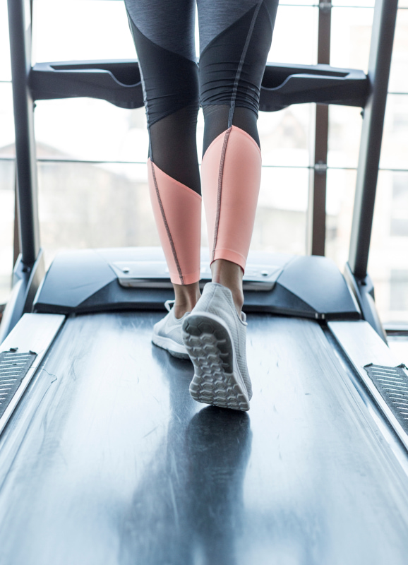 Person, die das Laufband im Fitnessraum benutzt