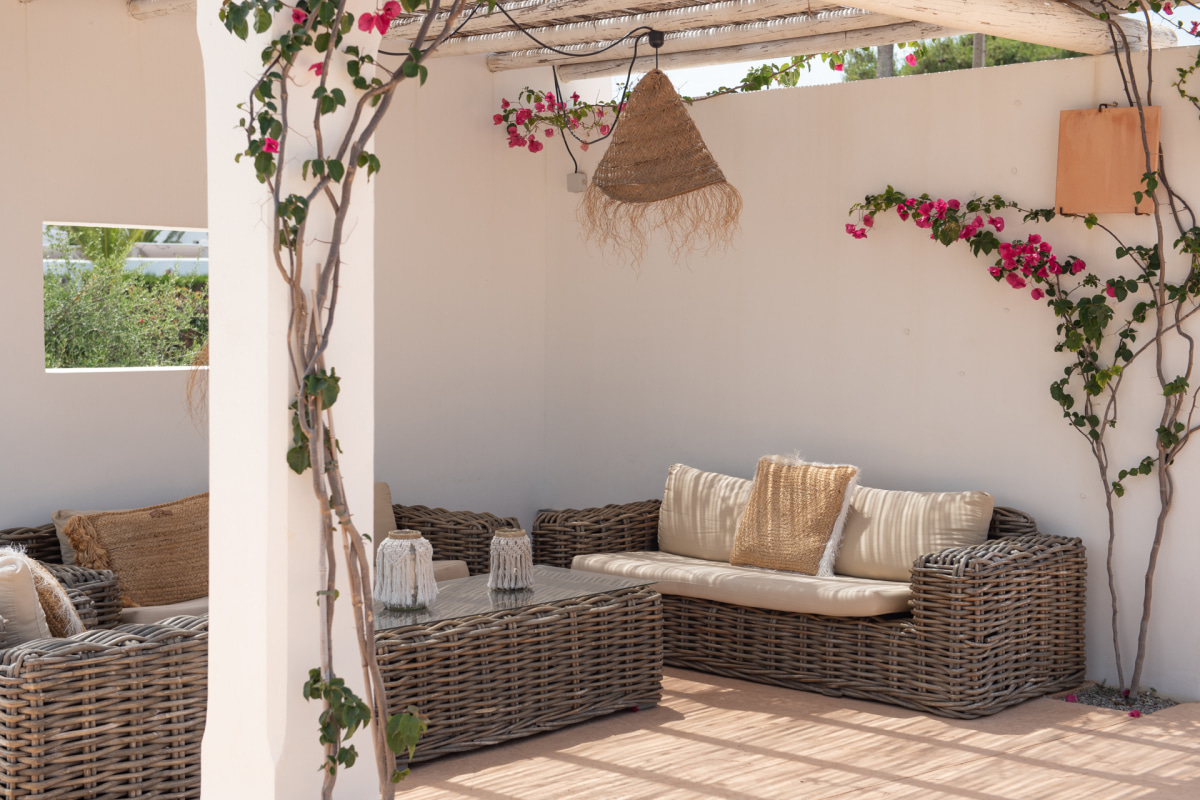 Una de las zonas chill out de la zona de piscina, con sofás de mimbre