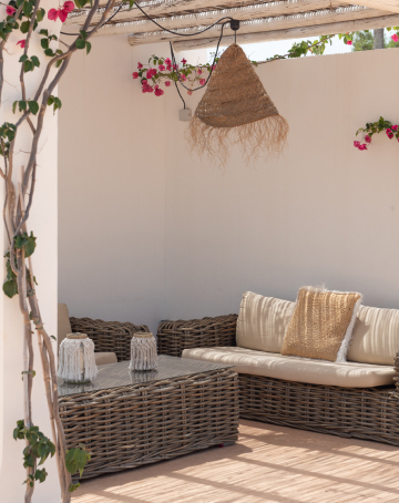 Una de las zonas chill out de la zona de piscina, con sofás de mimbre