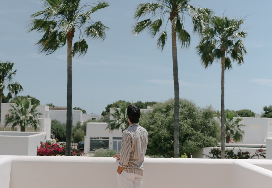 Ein Kunde lehnt sich auf dem Balkon aus, mit einem schönen Blick über das Resort.