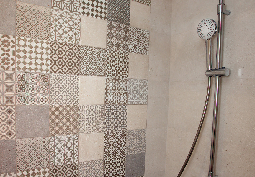 Detail of the shower, with geometric tiling in earthy colours