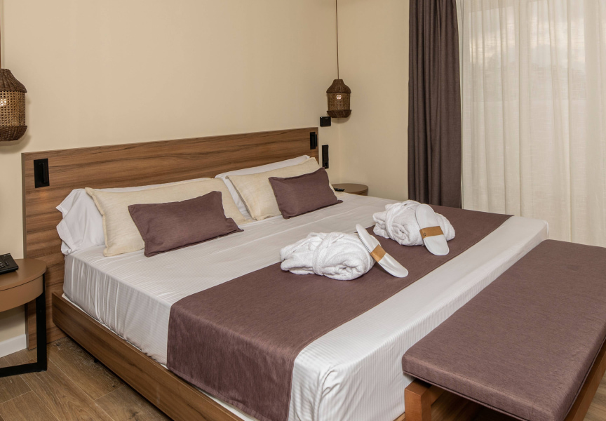 King size bed with bathrobes and slippers prepared for guests.