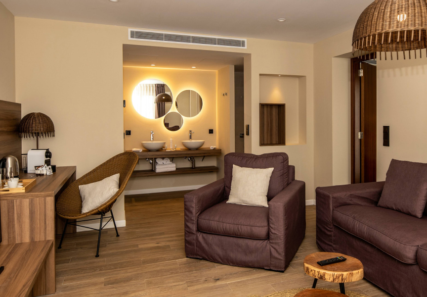 Detail of the living area of the room, with sofa, armchair and desk